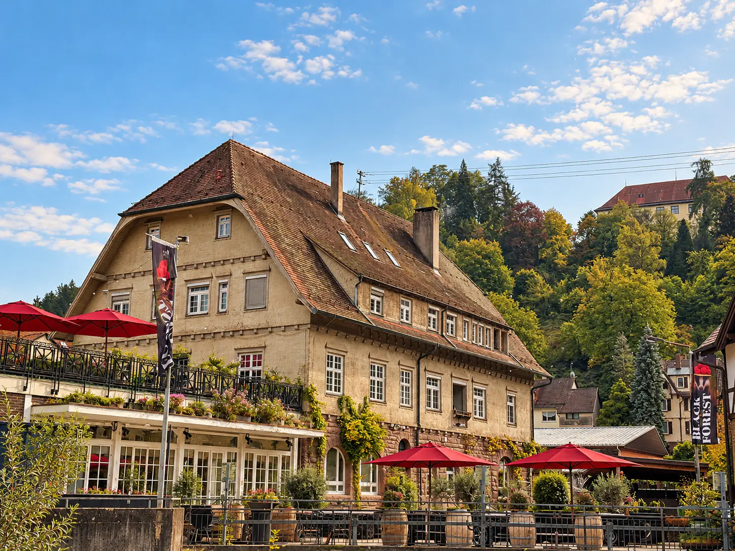 The old post office in Neuenbürg with its terrace, surrounded by the wooded hills of the northern Black Forest
